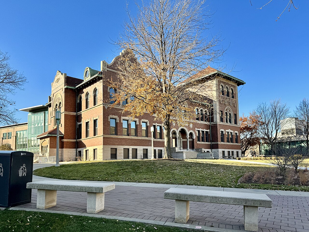 Dumbach Hall, a historic Mission Revival-style brick building with red terra cotta tile roof and corner tower at Loyola University Chicago campus / Wikimedia Commons