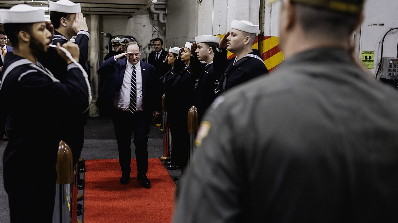 Secretary of the Navy John Phelan salutes as he passes through side boys on the ceremonial quarterdeck aboard Nimitz-class aircraft carrier USS George Washington, April 28, 2025 / U.S. Navy photo by Mass Communication Specialist 2nd Class August Clawson