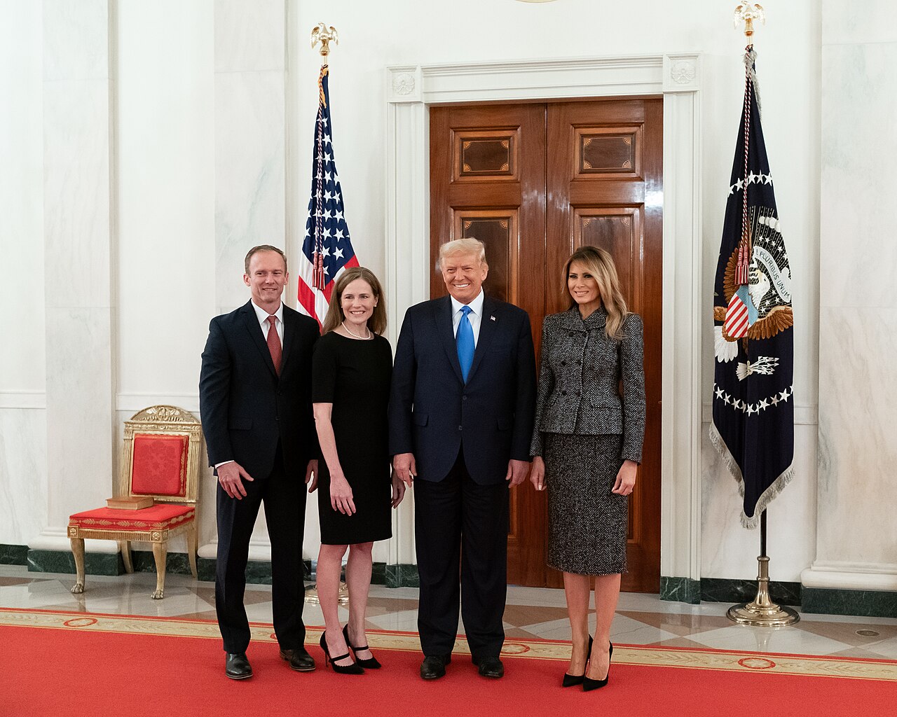 President Donald Trump and First Lady Melania Trump pose for a photo with Supreme Court Associate Justice Amy Coney Barrett in the Cross Hall of the White House / Official White House Photo by Andrea Hanks
