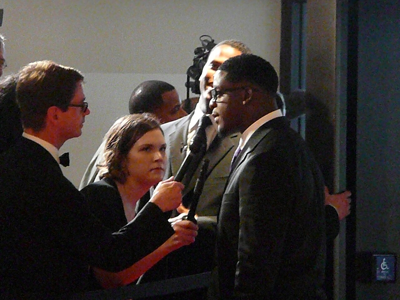 A ballroom event setup at a White House Correspondents' Dinner, showing a large dining hall with round tables, stage lighting, and event decor / Wikimedia Commons