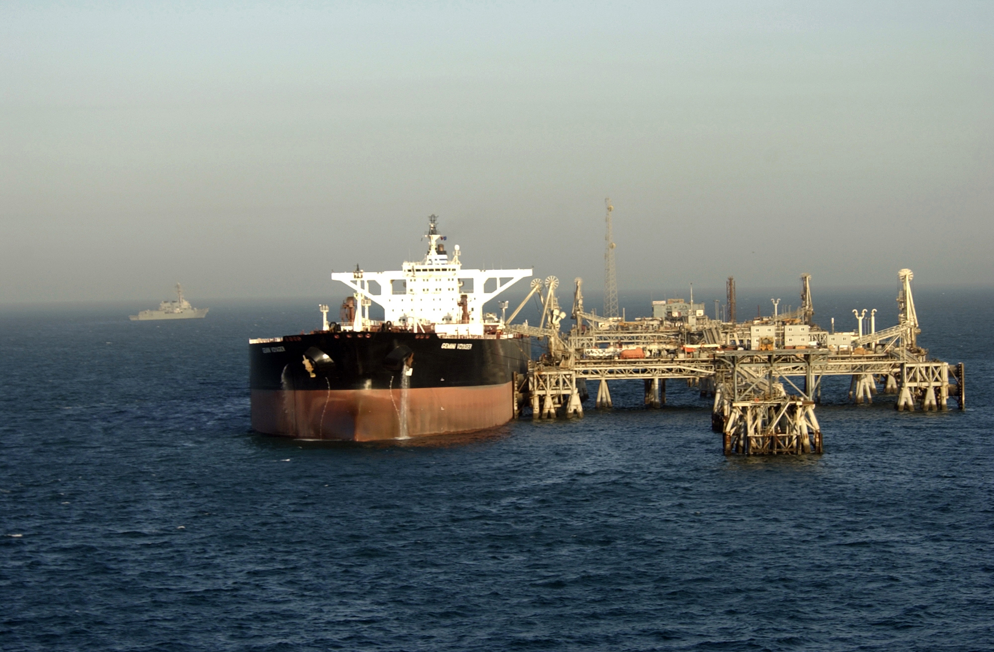 Al Basrah Oil Terminal (ABOT) in the North Arabian Gulf with a super tanker loading crude oil and guided missile destroyer USS Preble (DDG 88) patrolling nearby / U.S. Navy photo by Photographer's Mate 1st Class David C. Lloyd