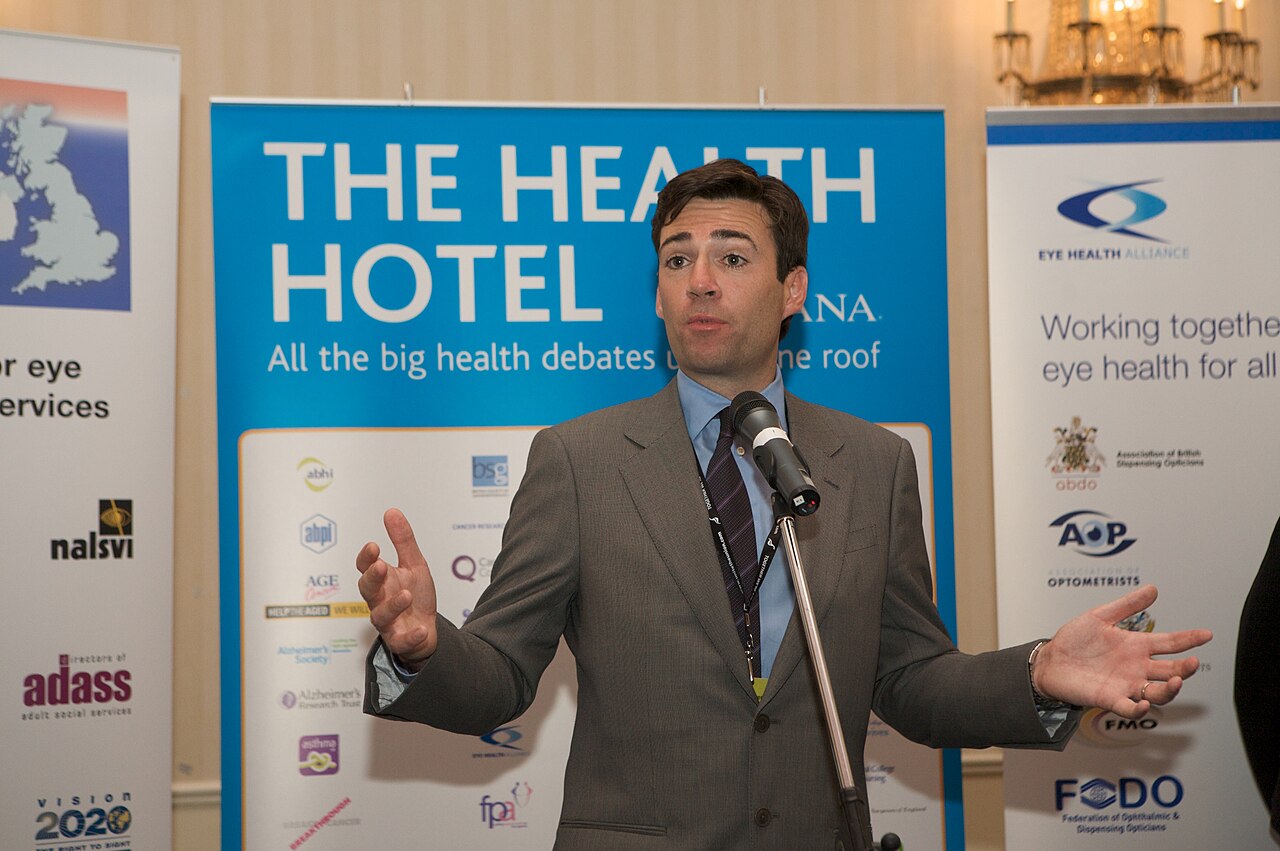 Andrew Burnham speaking at a podium during the Labour Party Conference Health Hotel reception in Brighton, September 2009 / Royal Photographic Society / Wikipedia Commons