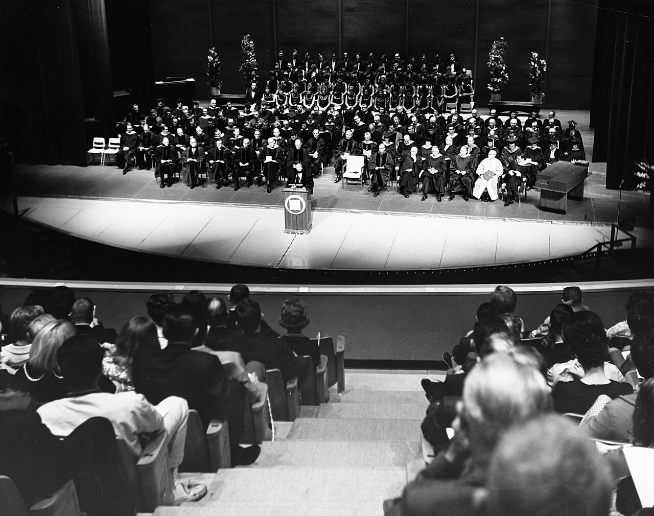Arlington State College graduation ceremony showing graduates in caps and gowns at an outdoor ceremony / Wikipedia Commons