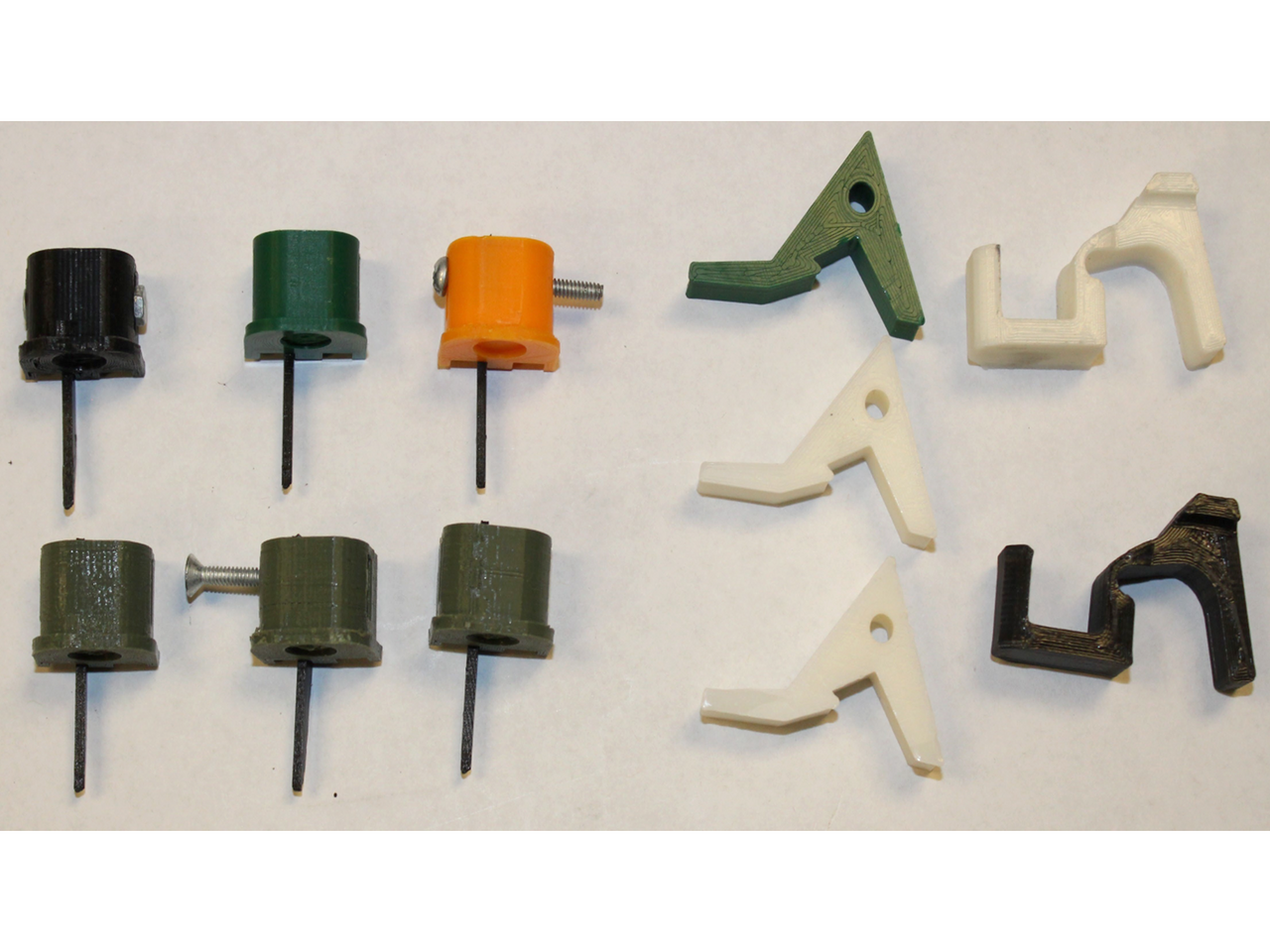 Privately made machine gun conversion devices including Glock switches on the left and swift link devices on the right, displayed against a white background / Public Domain