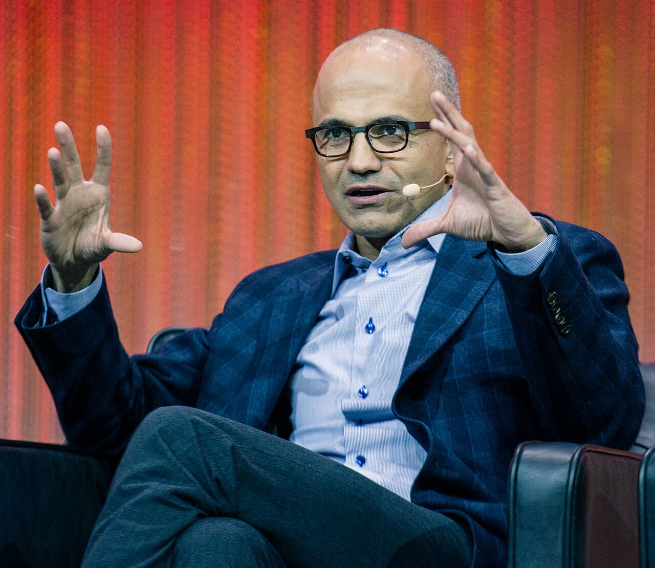 Portrait of Satya Nadella, CEO of Microsoft, in a suit and glasses against a plain background / Wikipedia user:Shizhao