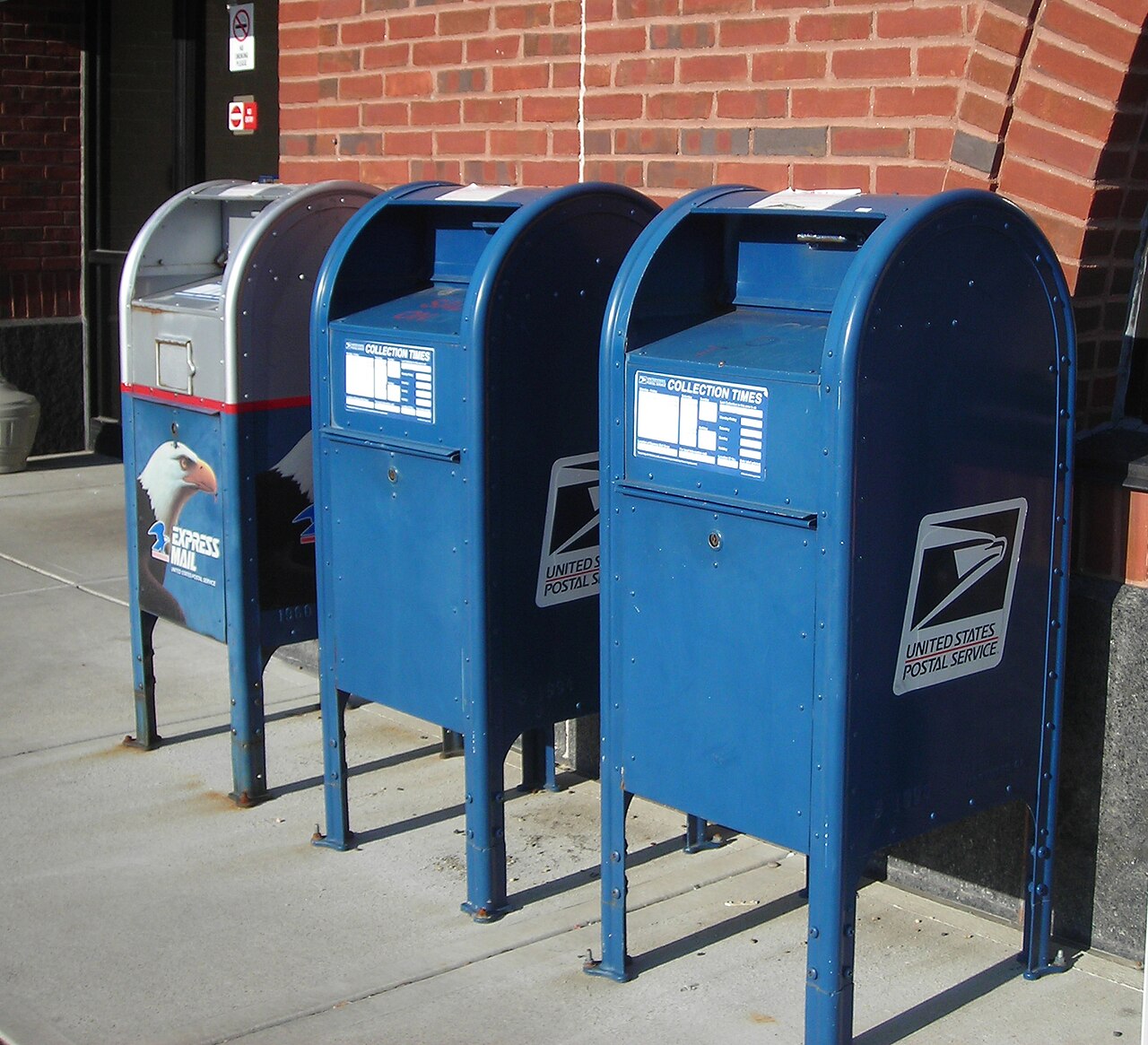 Blue United States Postal Service mail collection boxes on a city street / Public domain
