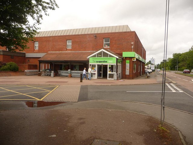 A small Co-Op supermarket in Holbury, UK, also housing a post office, representing a typical British grocery retailer / Photo by Dr. Bob - Geograph Britain and Ireland (CC BY-SA 2.0)